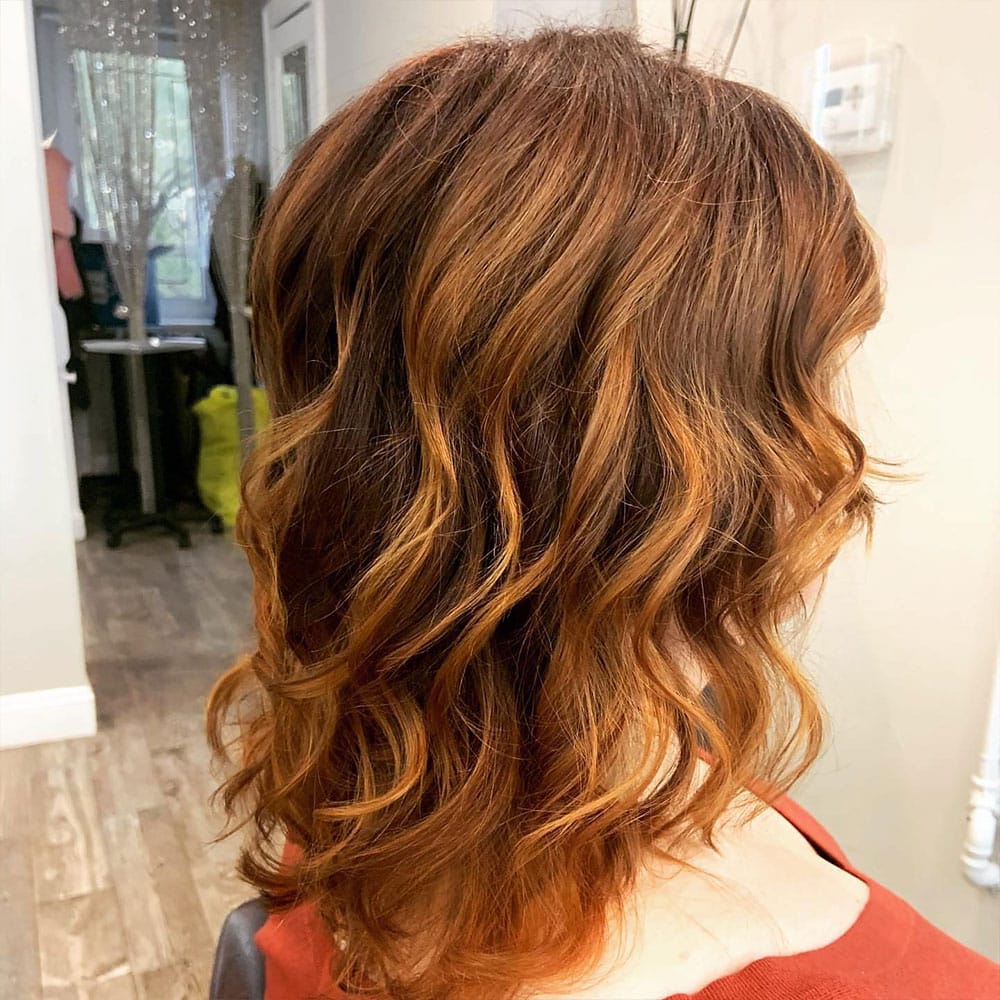 brunette woman with freshly dyed and blown out hair after coming from elmsford to numi hair salon