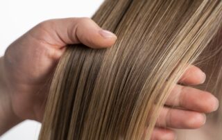 Smooth shiny hair after glaze treatment showing light reflection and dimensional color at Numi Hair Salon Scarsdale