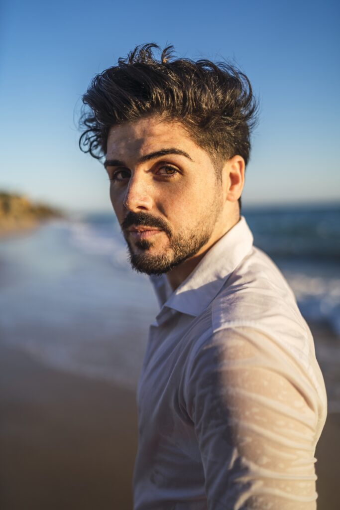 male model with quiff hairstyle posing near ocean near westchester new york by numi hair salon
