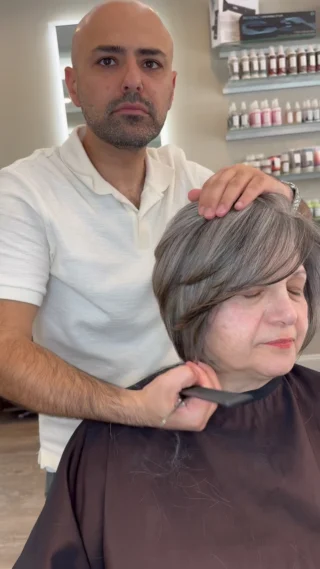 Stylist cutting a gray bob in the salon