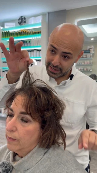 Stylist texturizing a client's shoulder-length hair